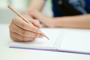 Asian teenage student write homework, study lesson for exam online learning education. photo