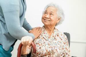 Caregiver help Asian elderly woman patient with love, care, encourage and empathy at nursing hospital, healthy strong medical concept. photo