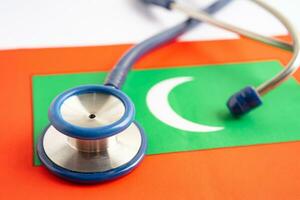 Stethoscope on Maldives flag background, Business and finance concept. photo