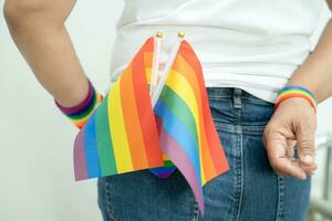 Woman holding LGBT rainbow colorful flag, symbol of lesbian, gay, bisexual, transgender, human rights, tolerance and peace. photo