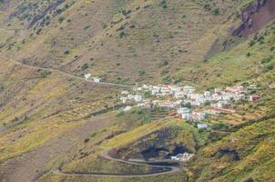 un pequeño pueblo en el lado de un montaña foto