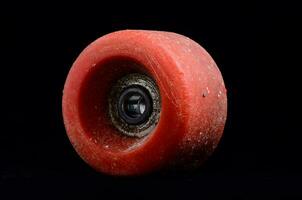 a red skateboard wheel on a black background photo