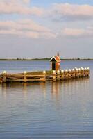 a small dock with a house on it in the middle of the water photo