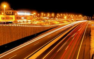 un autopista a noche con carros conducción en eso foto