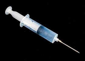 a syringe with a needle on a black background photo