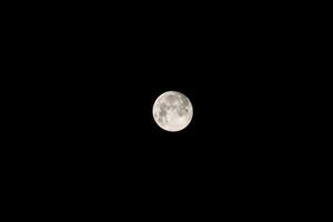 the moon is seen in the dark sky photo