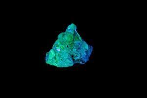 macro mineral stone opal under ultraviolet light on a black background photo