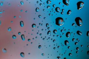 Beautiful multi-colored water droplets on a glass photo