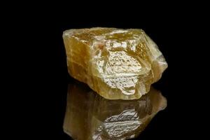 Macro mineral stone yellow Calcite on a black background photo