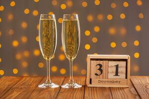 Glasses with champagne on a wooden background against a bokeh background of lights photo