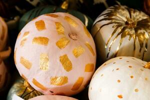 beautiful painted pumpkins of white and gold color on halloween photo