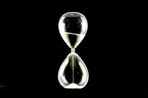 an hourglass with a black background photo