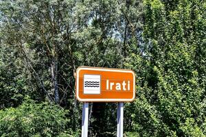 An orange street sign that says Irati photo