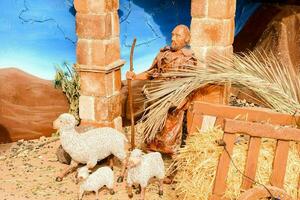 un natividad escena con un pesebre, oveja y un pastor foto