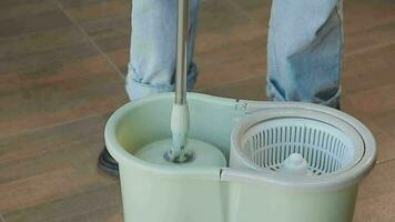 Housewife using vacuum cleaner on the floor. Wearing an apron to clean the living room at house. Young woman is happy to clean home. Maid cleaning service. video