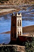 a small building sits next to a river photo