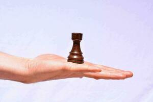 mano sosteniendo una pieza de ajedrez foto