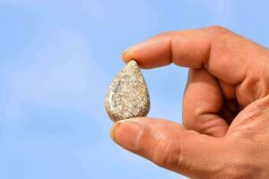 Hand holding a stone photo