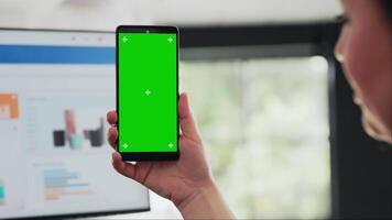 Frau hält Smartphone beim Schreibtisch, Überprüfung isoliert grüner Bildschirm Vorlage vorgestellt auf Handy, Mobiltelefon Gerät. Geschäft Manager Arbeiten mit modern Layout Technologie, Chromakey Exemplar. schließen hoch. video