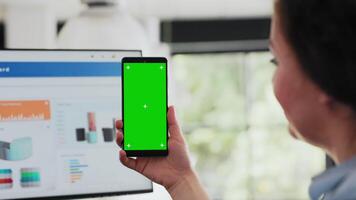 arbeider controle groene scherm Scherm Aan smartphone, Holding apparaat met copyspace blanco software in coworking ruimte. vrouw werken met geïsoleerd mockup Scherm in agentschap kantoor. dichtbij omhoog. video