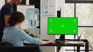 Businesswoman working at computer running isolated mockup display, sitting at office desk during work program. Employee using modern monitor with greenscreen copyspace layout at job. video