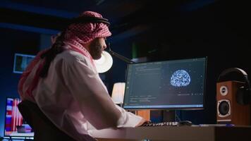 Developer typing on keyboard, updating artificial intelligence neural networks, writing complex binary code scripts. Muslim freelance programmer in personal office upgrading high tech AI video