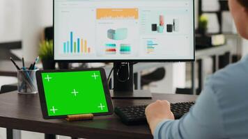 la personne en utilisant tablette avec chromakey conception sur afficher, séance à bureau et en cours d'analyse produit Ventes sur ordinateur. entreprise ouvrier à la recherche tous les deux à isolé maquette modèle et revenu réseau sur pc. video