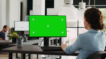 Startup manager using greenscreen display on computer at workstation, checking modern network with isolated copyspace template. Businesswoman working with mockup chromakey screen. video