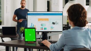 attività commerciale persona utilizzando pc a postazione di lavoro, avendo schermo verde Schermo modello su tavoletta nel davanti di suo. manager pianificazione avviare operazioni e controllo isolato modello disposizione su dispositivo. video