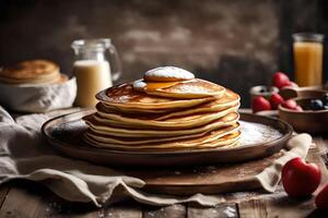 Stack of pancakes with syrup and berries on a wooden table photo