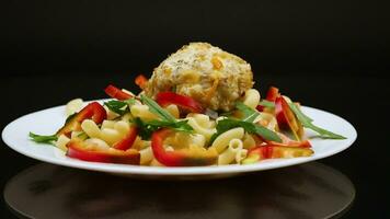 cooked pasta with meatballs, peppers and herbs with spices in a plate video