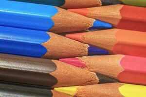 Set of colored pastel pencils in row multi color in form of a closed zipper and pencil sharpener photo