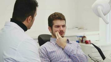 Handsome young man having toothache visiting dentist video