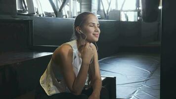 Cheerful young fitness woman enjoying listening music at the gym video