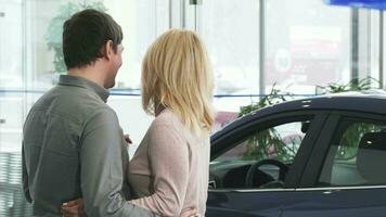 vue arrière coup de une mature couple examiner une Nouveau voiture à le concession video