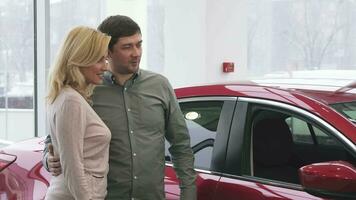 vrolijk volwassen paar buying een nieuw auto Bij de handel toonzaal video