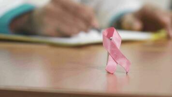 Pink ribbon breast cancer awareness symbol on the table of a doctor video