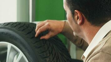 The smart man carefully studying the rubber of new wheels video