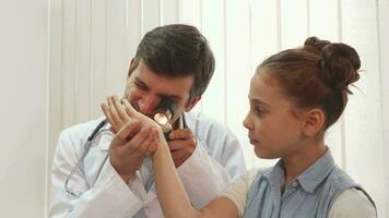 A nice little girl is sitting quietly while the doctor examines her video