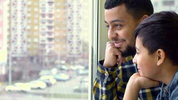 Vater und Sohn aussehen aus das Fenster video