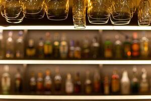 Clean wine glasses hanging over the bar counter on out of focus background photo