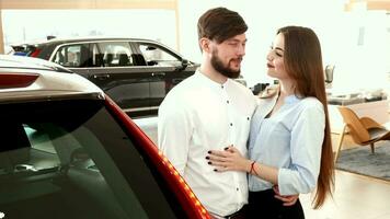 Couple embraces each other near the car at the dealership video