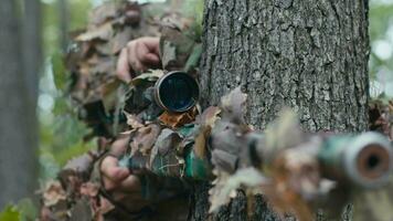 de face coup concentré sur portée ajusté par camouflé tireur d'élite dans forêt video