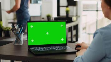 bedrijf specialist gebruik makend van laptop met groene scherm sjabloon, werken met mockup Chroma sleutel Scherm Aan pc. vrouw analyseren geïsoleerd copyspace lay-out Aan scherm, werken Bij kantoor bureau. video