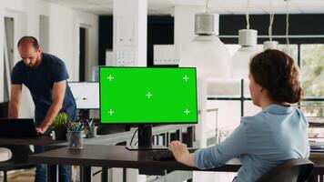 operatör av företag förlita sig på Chromakey isolerat grönskärm visa. företag verkställande använder sig av dator på börja arbetsplats medan granskning attrapp mall, arbetssätt i byrå kontor. stativ skott. video
