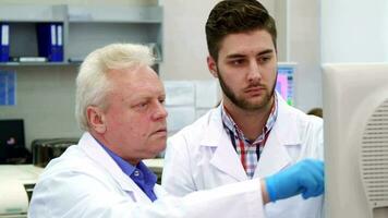 homem pontos dele mão em monitor às a laboratório video