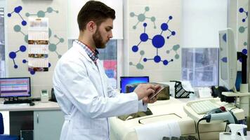 Man enters information from computer to the tablet at the laboratory video