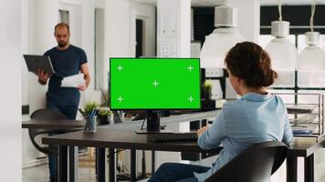 Specialist looking at greenscreen template on desktop monitor in small business agency workplace. Person checking isolated display showing blank chromakey mockup, problem solving. Tripod shot. video