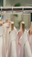 verticale vidéo proche en haut coup de haute qualité habits dans prime Vêtements magasin. élégant vêtements de cérémonie blanc chemises dans vide nouvellement ouvert luxueux mode boutique en attente clients, foc vers le bas coup video