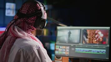 Middle Eastern content creator editing cinematographic project in post production process, working with images and sounds. Teleworking artist doing video selection on computer screen